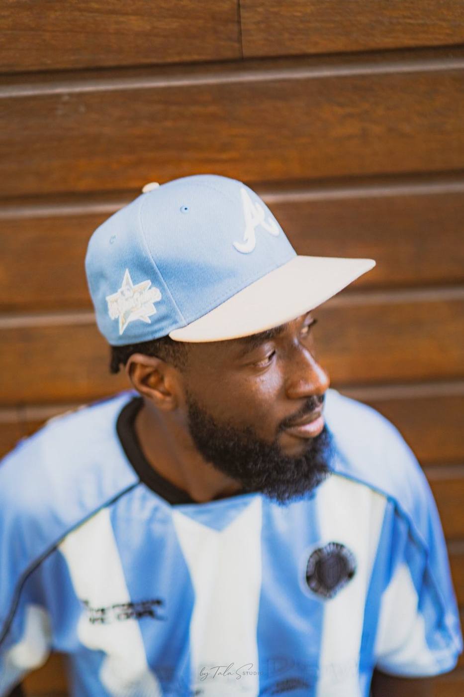 Portrait pro casquette bleue devant un mur en bois