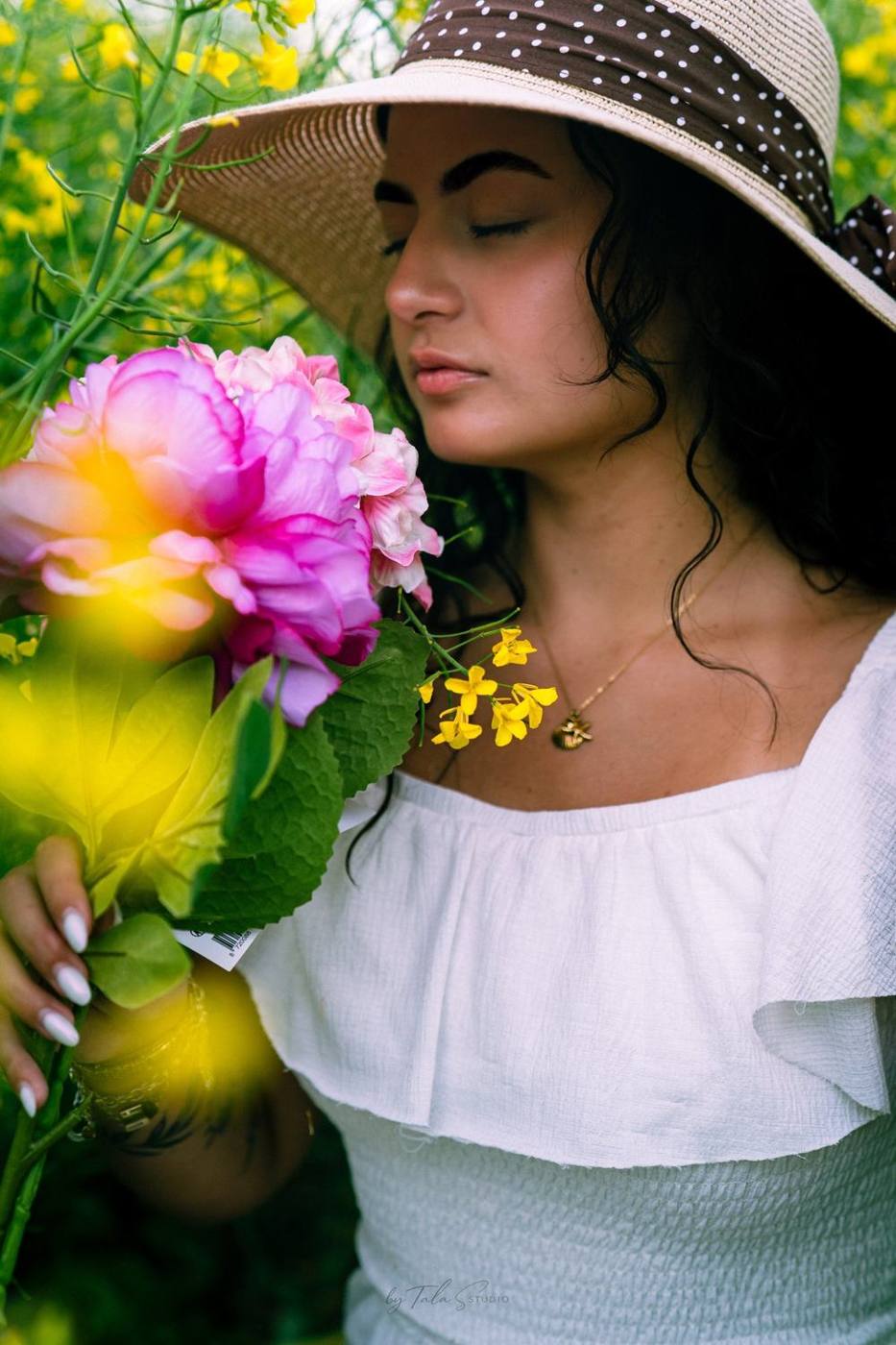 Portrait chapeau de paille et pivoines dans un champ de colza